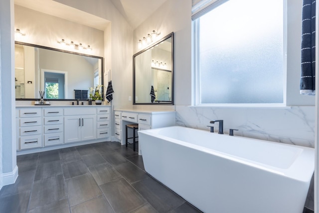 bathroom with vanity and a freestanding tub