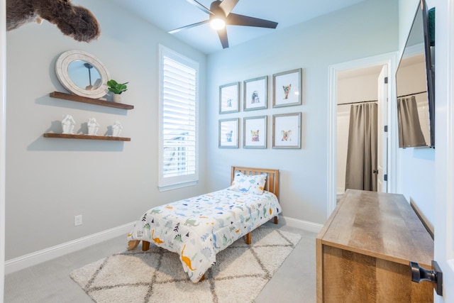 carpeted bedroom with ceiling fan and baseboards