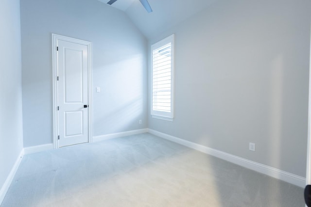 spare room featuring a wealth of natural light, light carpet, ceiling fan, and vaulted ceiling