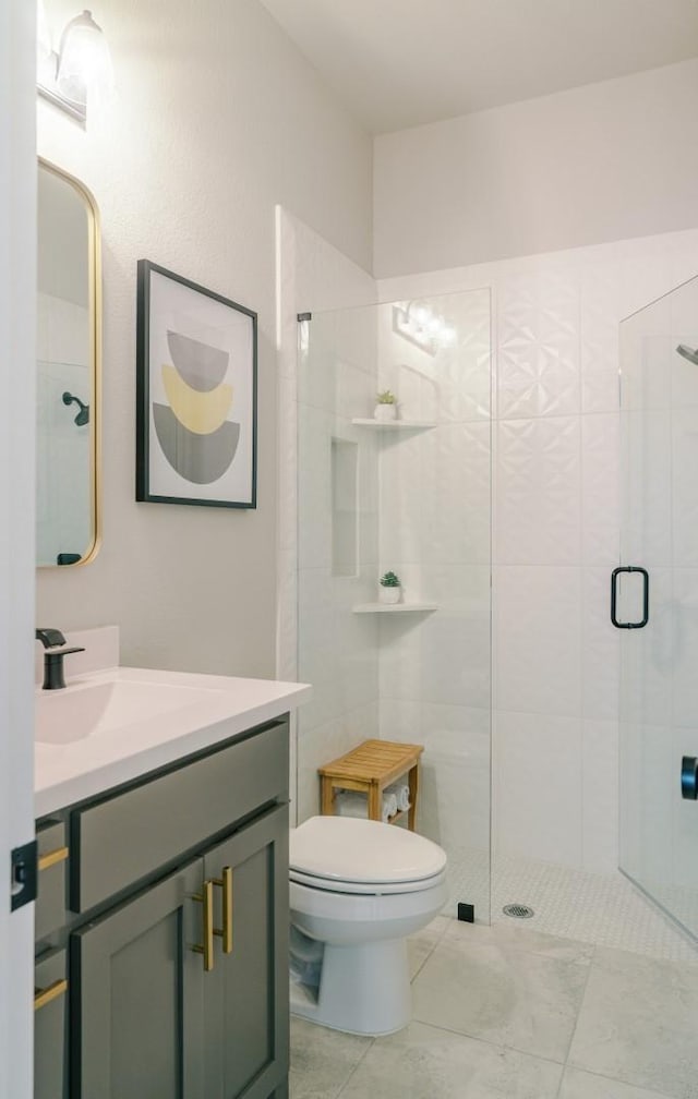 bathroom with vanity, a shower stall, and toilet