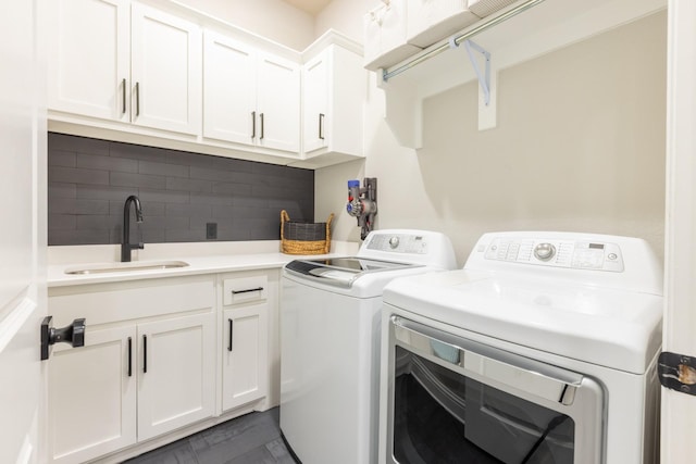 washroom with a sink, cabinet space, and washing machine and clothes dryer