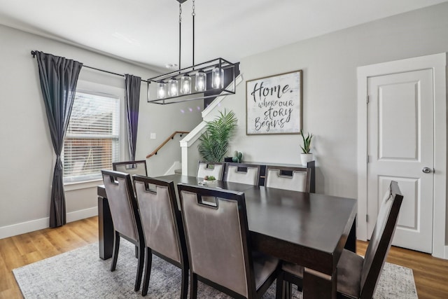 dining area featuring stairway, baseboards, and wood finished floors