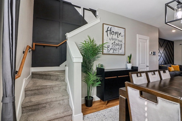 stairs with wood finished floors and recessed lighting