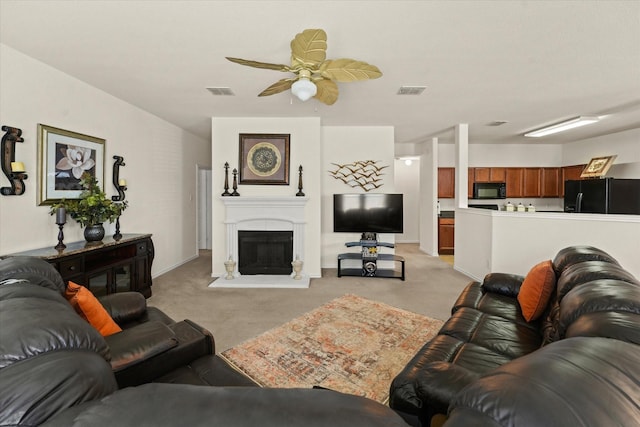 living room featuring light carpet, a fireplace with raised hearth, and visible vents