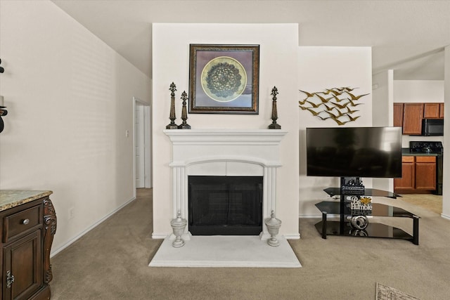 carpeted living area featuring a fireplace with raised hearth and baseboards