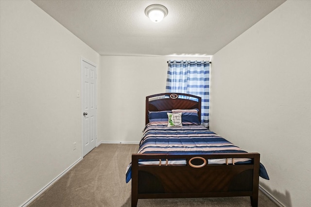 carpeted bedroom with baseboards and a textured ceiling