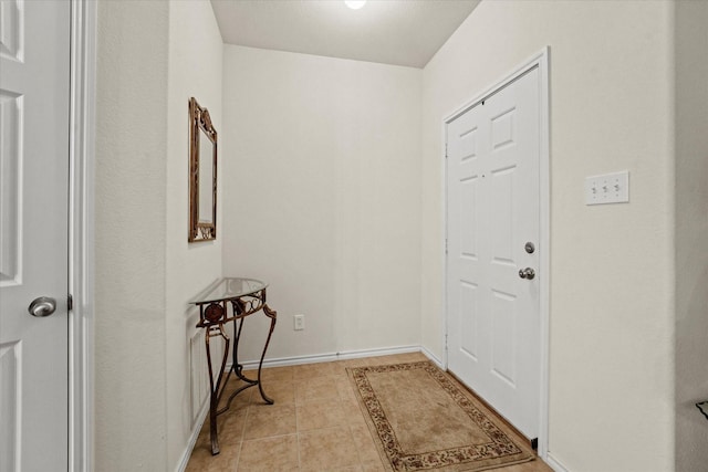 entryway featuring light tile patterned floors and baseboards