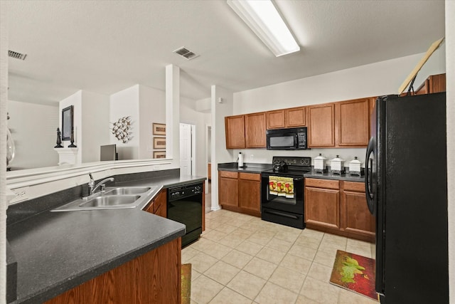 kitchen featuring dark countertops, black appliances, visible vents, and brown cabinets