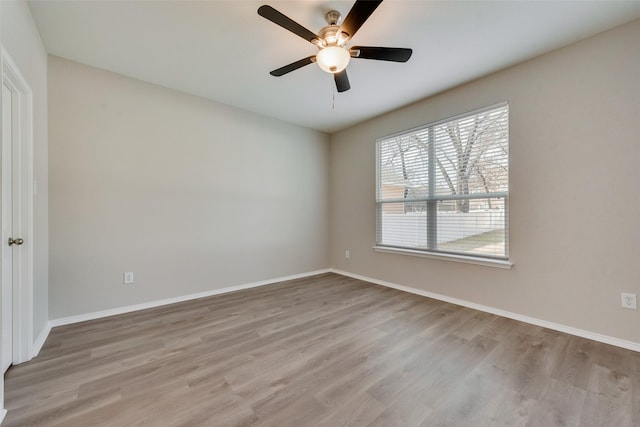 unfurnished room featuring ceiling fan, light wood-style flooring, and baseboards