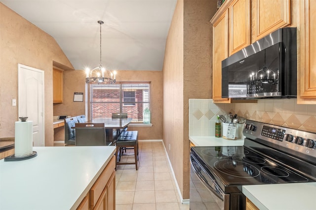 kitchen featuring vaulted ceiling, appliances with stainless steel finishes, decorative backsplash, and an inviting chandelier