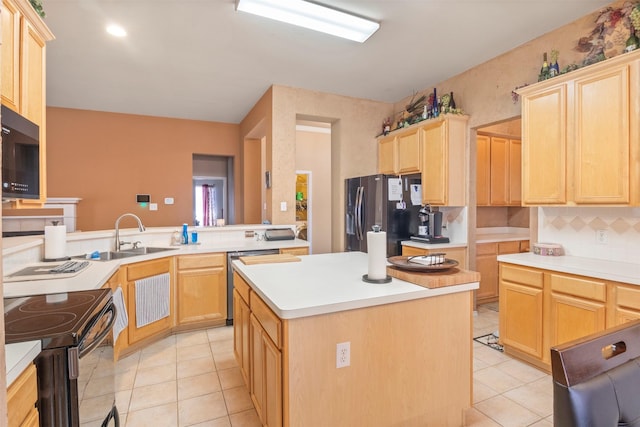 kitchen featuring light tile patterned floors, black appliances, light brown cabinetry, and a sink