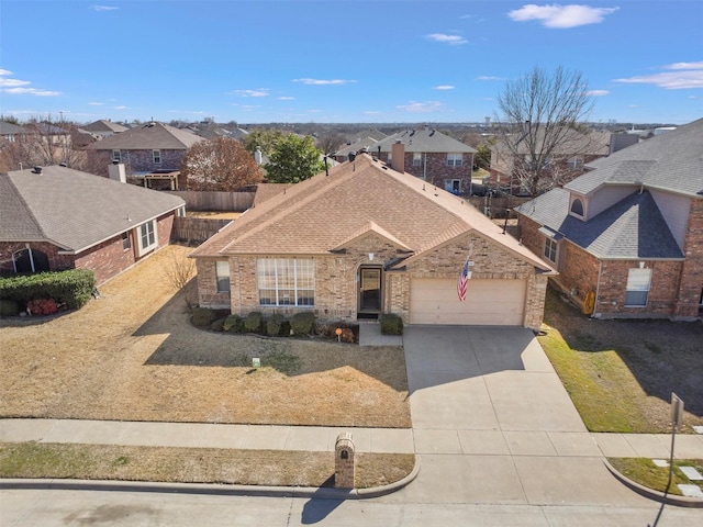 view of front of home featuring brick siding, concrete driveway, an attached garage, fence, and a residential view