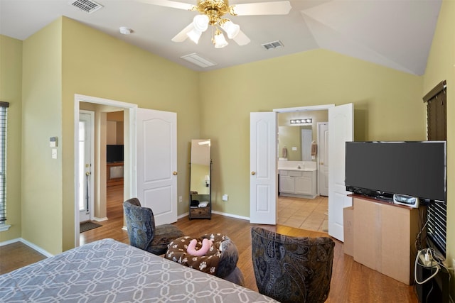 bedroom with lofted ceiling, visible vents, baseboards, and wood finished floors