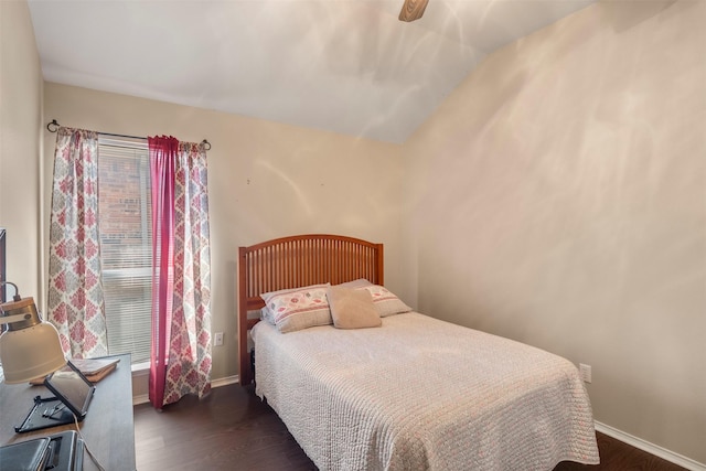 bedroom with lofted ceiling, dark wood-style flooring, and baseboards