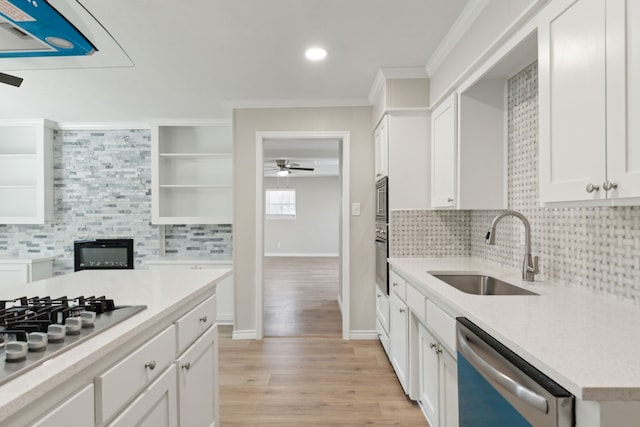 kitchen with crown molding, open shelves, appliances with stainless steel finishes, white cabinetry, and a sink