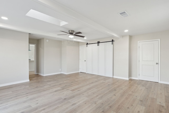 unfurnished room featuring a skylight, light wood finished floors, recessed lighting, visible vents, and baseboards