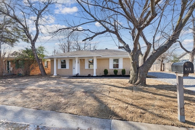 ranch-style house featuring brick siding and fence