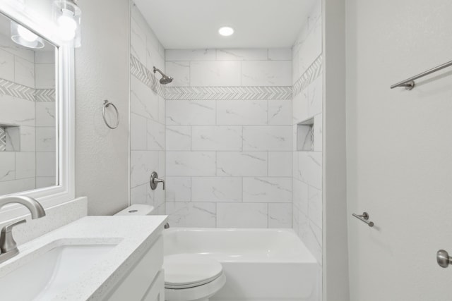 full bath featuring a textured wall, shower / bath combination, vanity, and toilet