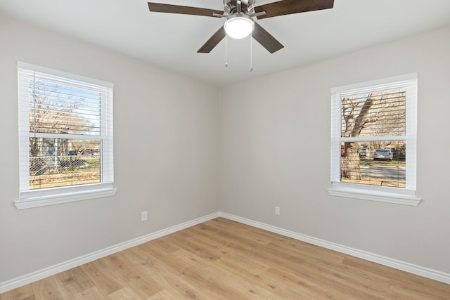 spare room with ceiling fan, light wood-style floors, and baseboards