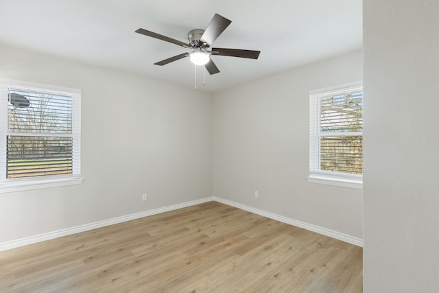 unfurnished room with a ceiling fan, light wood-type flooring, and baseboards