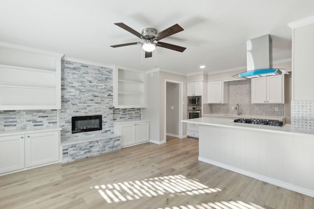 kitchen with stainless steel appliances, island exhaust hood, open shelves, and crown molding