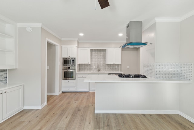 kitchen featuring white cabinets, appliances with stainless steel finishes, range hood, light countertops, and a sink