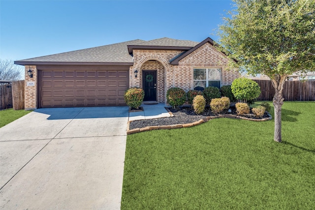 view of front of home featuring brick siding, a front lawn, an attached garage, and fence