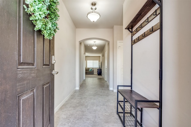 hall with arched walkways and baseboards