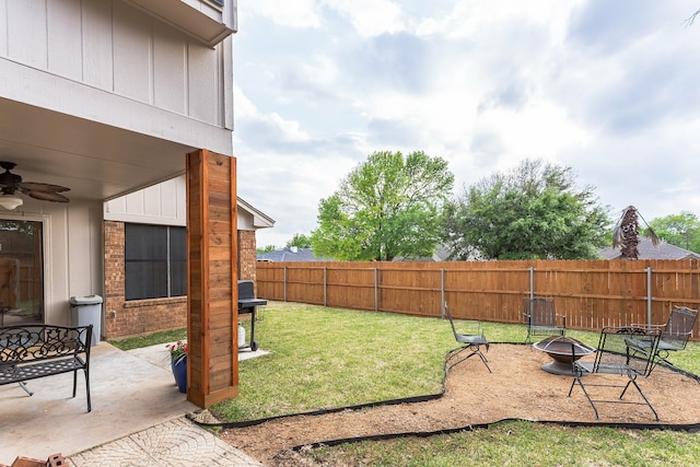 view of yard featuring a fire pit, a patio area, fence, and a ceiling fan