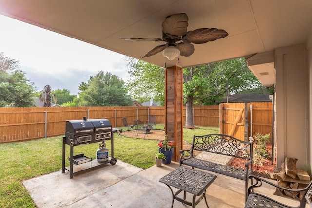 view of patio with ceiling fan, area for grilling, and a fenced backyard