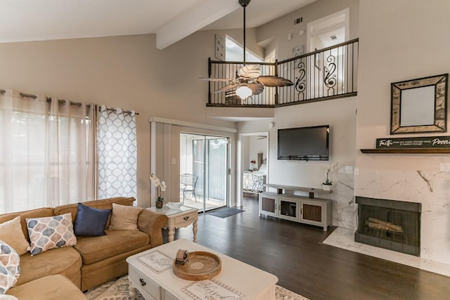 living room with ceiling fan, high vaulted ceiling, a fireplace, wood finished floors, and beamed ceiling