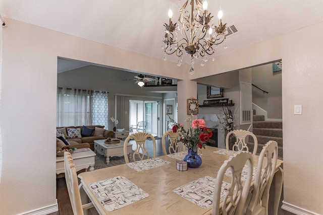 dining room featuring ceiling fan with notable chandelier, a textured ceiling, and stairs