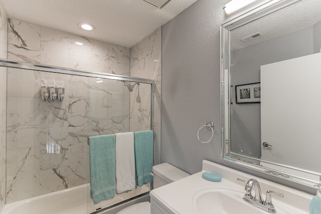 full bathroom featuring visible vents, toilet, combined bath / shower with glass door, vanity, and a textured ceiling