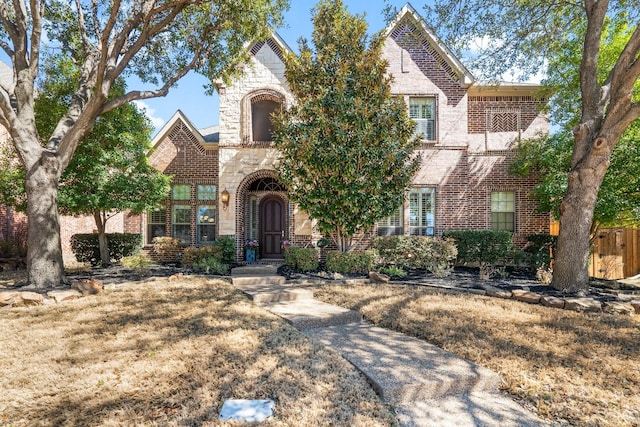 view of front of house with stone siding, fence, and brick siding