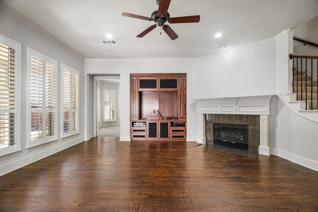 unfurnished living room featuring visible vents, wood finished floors, stairs, crown molding, and a fireplace