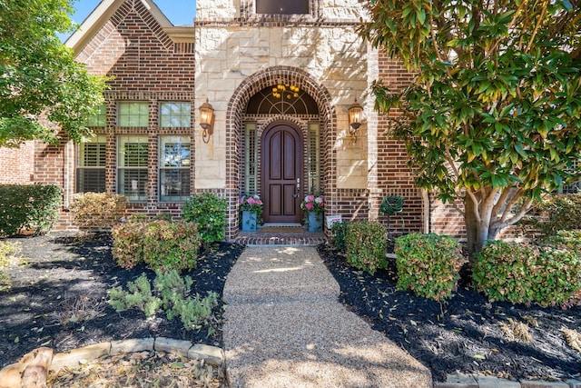 view of exterior entry featuring brick siding