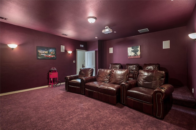 carpeted cinema featuring baseboards, visible vents, and a textured ceiling