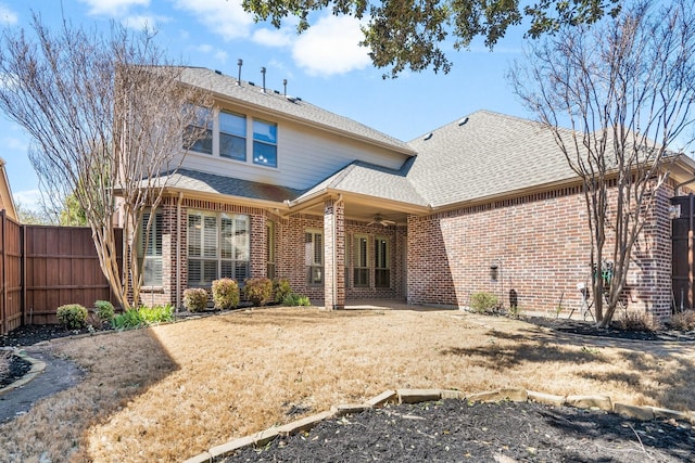 back of property featuring roof with shingles, fence, a ceiling fan, and brick siding