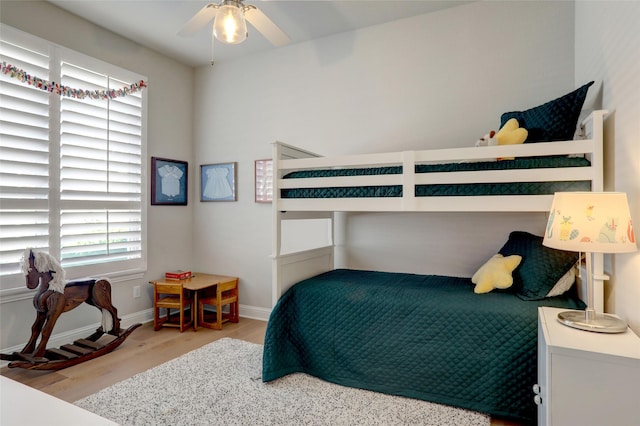 bedroom featuring ceiling fan, baseboards, and wood finished floors