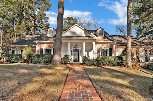 neoclassical / greek revival house featuring brick siding and a front lawn