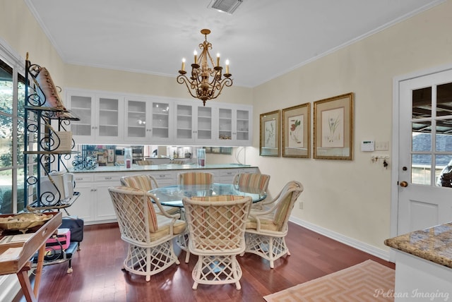 dining room featuring dark wood finished floors, visible vents, and crown molding