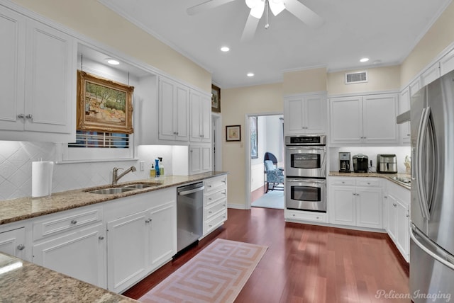 kitchen featuring stainless steel appliances, white cabinets, visible vents, and a sink