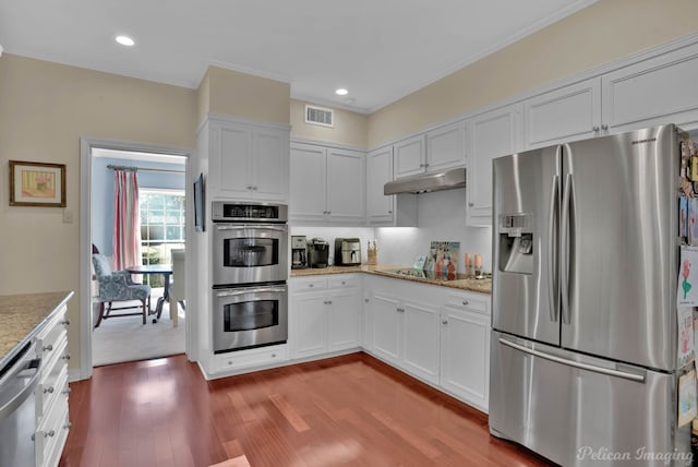 kitchen featuring stainless steel appliances, white cabinetry, visible vents, and under cabinet range hood