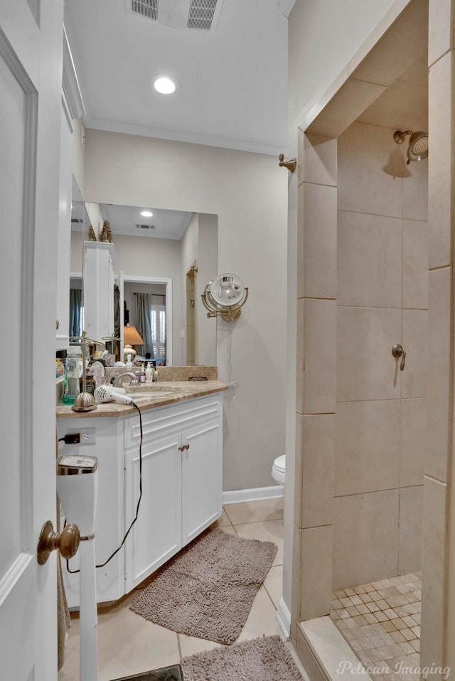 bathroom featuring toilet, visible vents, tiled shower, and vanity