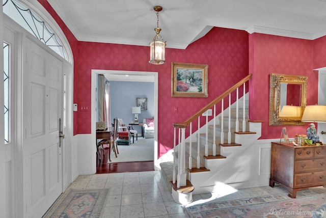 foyer with wallpapered walls, stairway, and ornamental molding