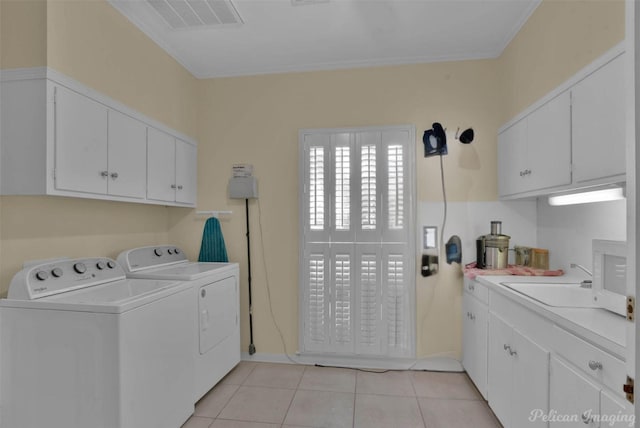 washroom with washer and clothes dryer, cabinet space, visible vents, light tile patterned flooring, and a sink