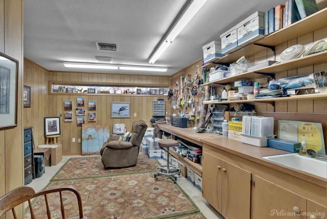 office space with a textured ceiling, visible vents, and a workshop area