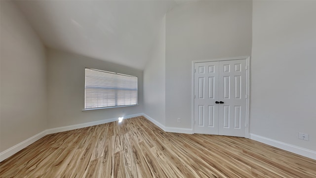 unfurnished room with a high ceiling, wood finished floors, and baseboards