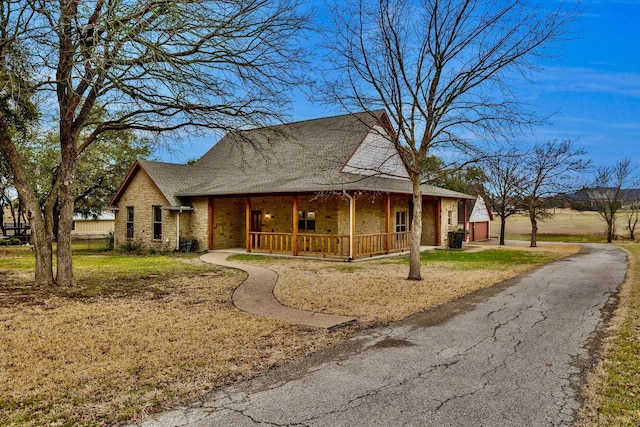 country-style home featuring stone siding and covered porch