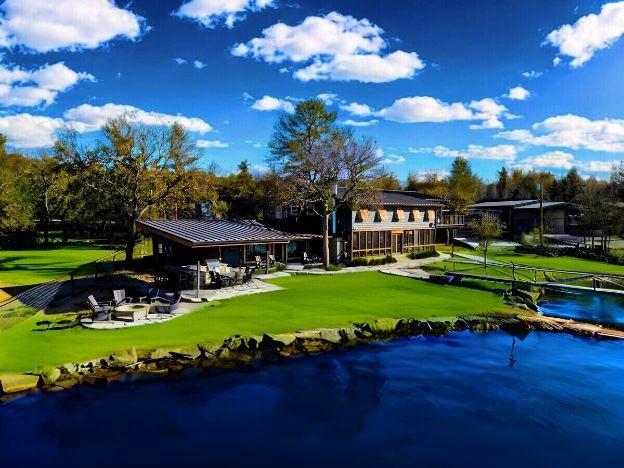 back of property featuring a patio, a lawn, and a water view